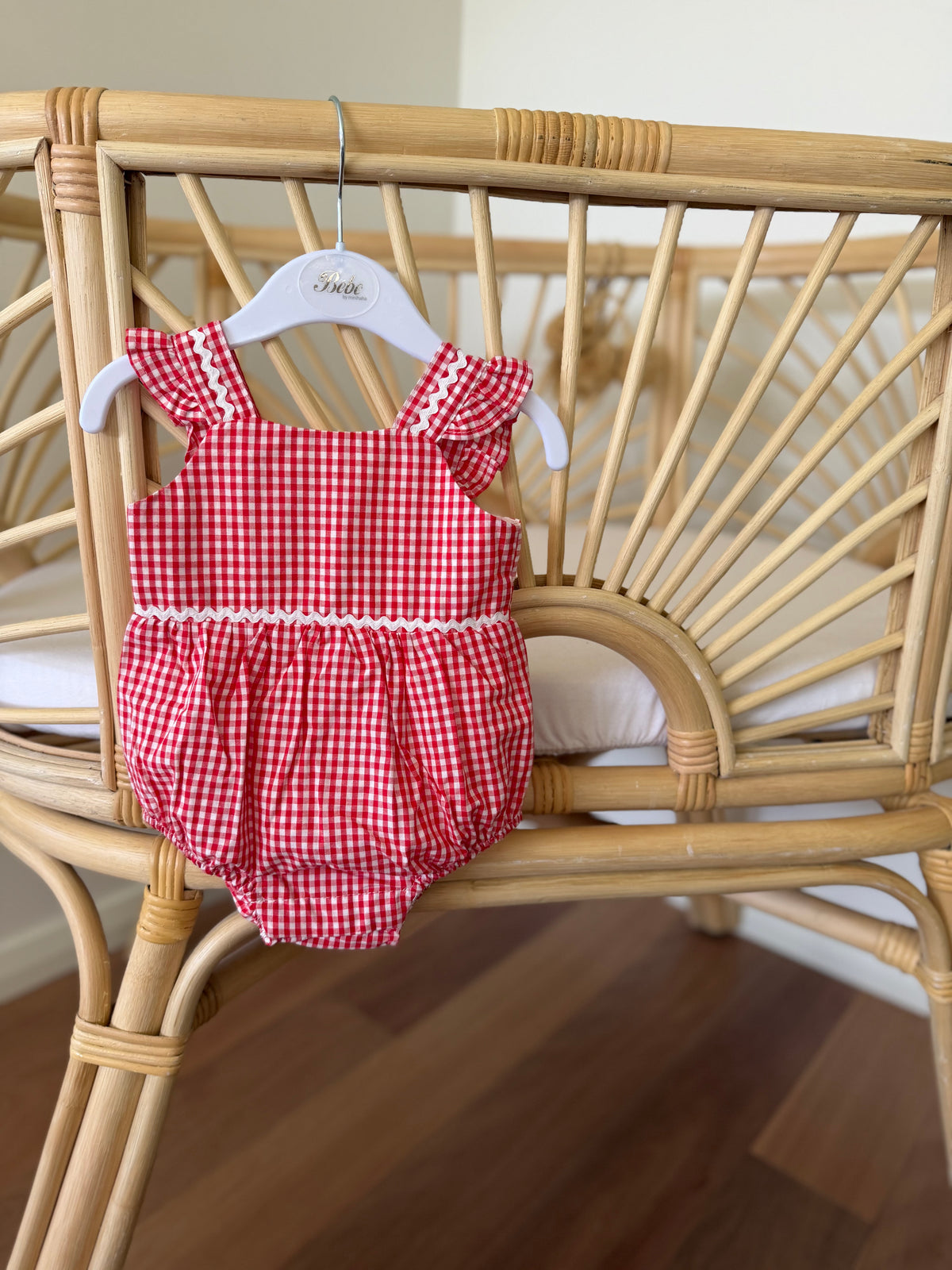 A red and white gingham baby romper with ruffled shoulder straps and a ruffled waistband, red gingham romper at Tajoh and gg